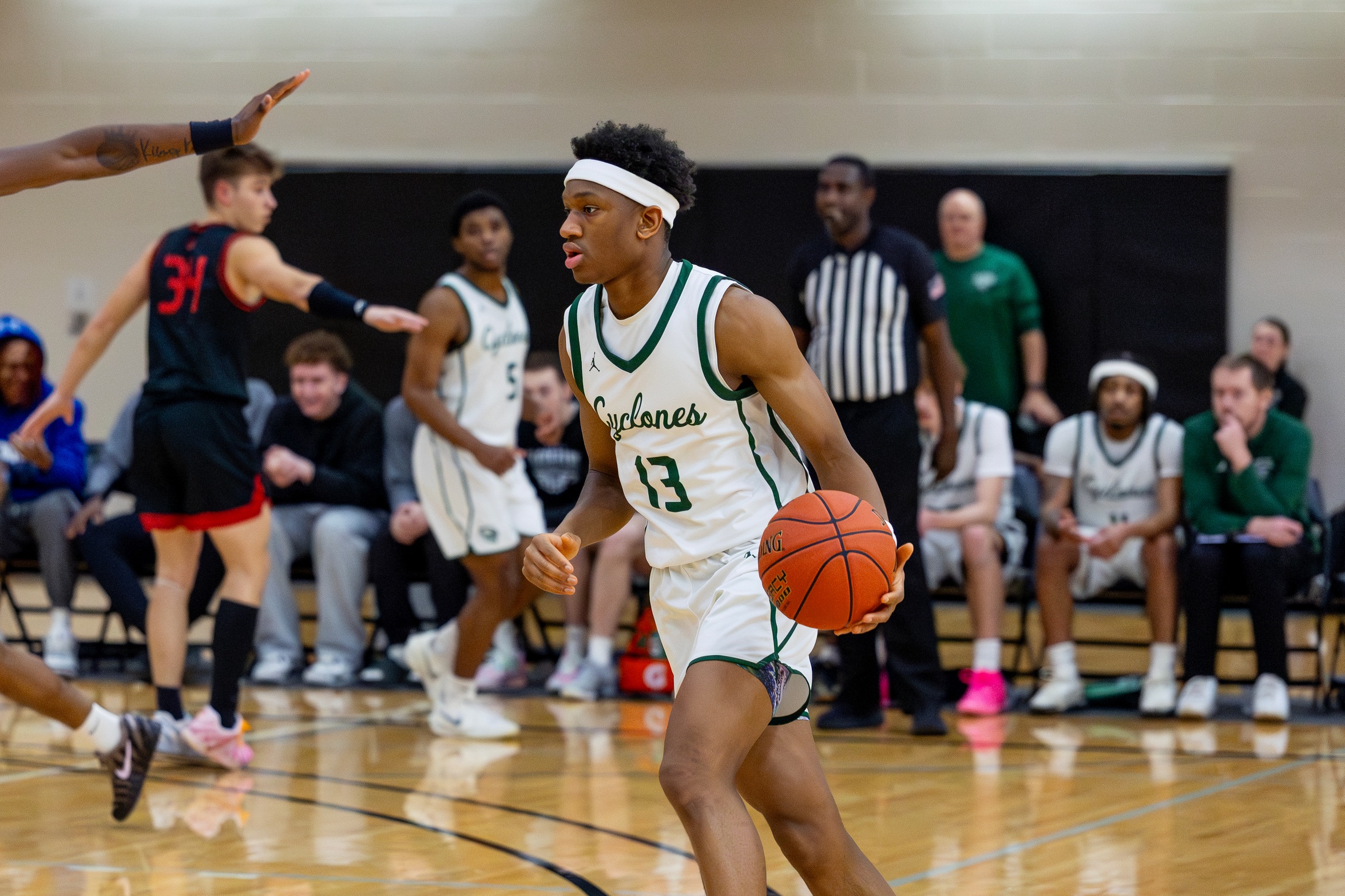 #13 Ismael Traore dribbling the ball during a basketball game.
